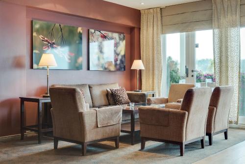 a living room with chairs and a table at Tyrifjord Hotell in Vikersund