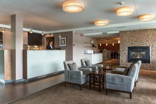 a woman standing at a bar in a hotel lobby at Tyrifjord Hotell in Vikersund