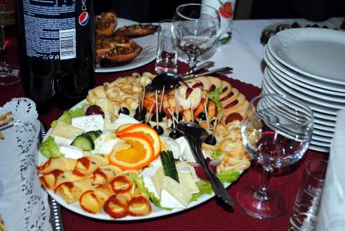 a plate of food on a table with glasses of wine at Penzión Slávia in Poprad