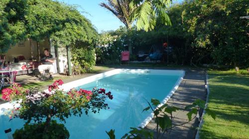 a pool in a yard with a man sitting in a chair at Ashcroft Gardens Bed & Breakfast in Napier
