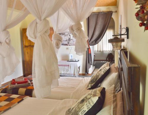 sypialnia z łóżkiem z baldachimem i zasłonami w obiekcie Ouhave Country Home w mieście Imkerhof