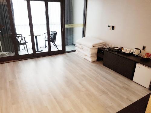 a living room with a wooden floor and large windows at Hotel Wooyeon Flora in Boryeong