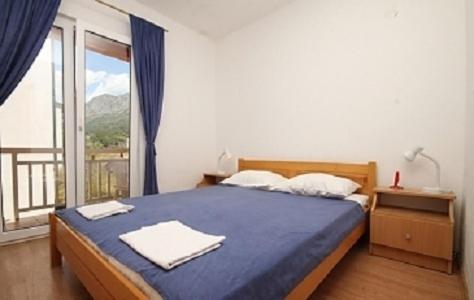 - une chambre avec un lit et une grande fenêtre dans l'établissement Villa Elvira, à Gradac