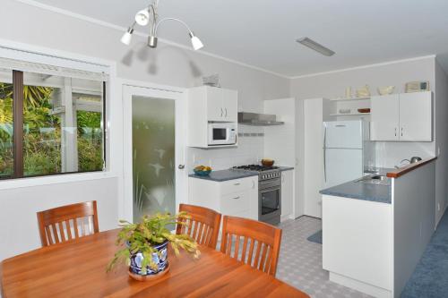 a kitchen and dining room with a table and chairs at Austria Motel in Paihia