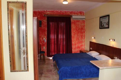 a bedroom with a blue bed and a red curtain at Crystal in Kavos