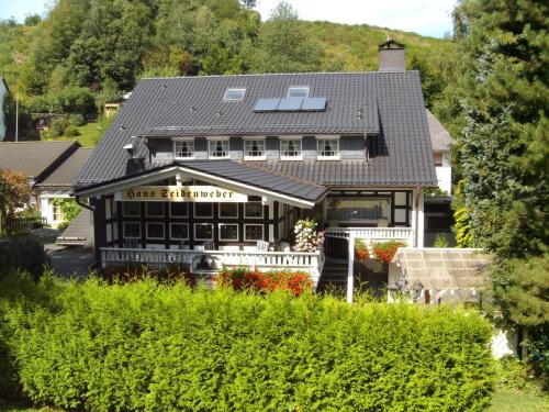 a house with a restaurant with a roof at Pension Haus Seidenweber in Schmallenberg