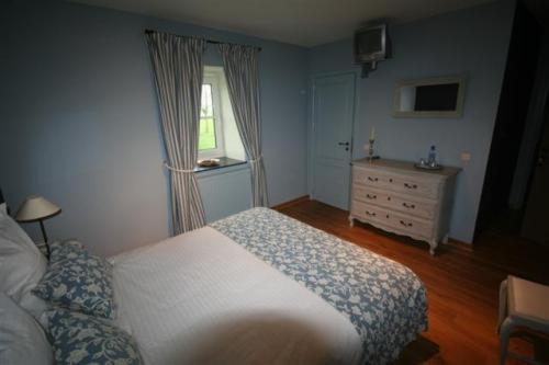 a bedroom with a bed and a dresser and a window at Hostellerie au Coeur du Spinois in Rebecq-Rognon