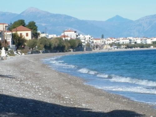 a view of a beach with buildings and the water at Akri Rooms in Akrata