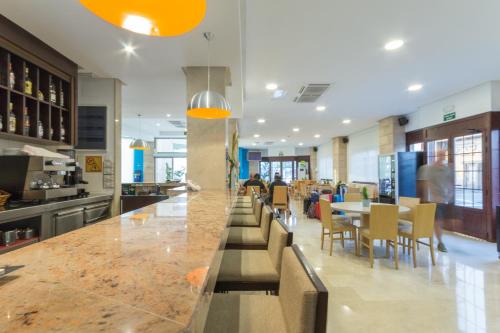 a restaurant with a bar with tables and chairs at Hotel Orosol in San Antonio