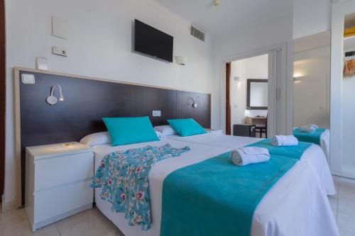 two beds in a bedroom with blue and white at Hotel Orosol by Typic Hotels in San Antonio