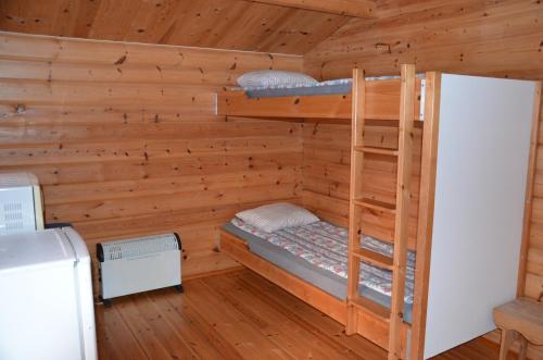 a bedroom with bunk beds in a log cabin at Käringsund Resort Camping in Eckerö