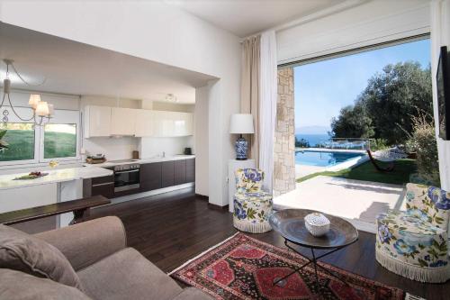a kitchen and a living room with a large window at Kappa Resort in Paliouri