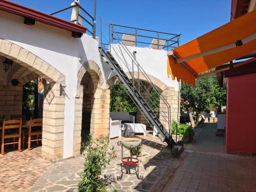 a building with a staircase on the side of it at Hotel Village Eden in Capo Vaticano