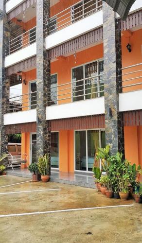 ein orangefarbenes Gebäude mit Pflanzen davor in der Unterkunft B and B Hotel in Ranong