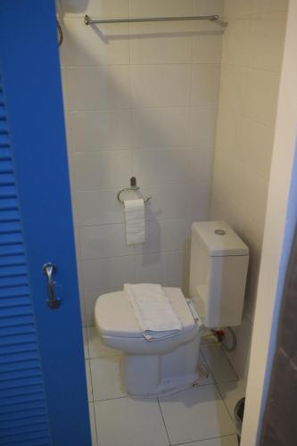 a white toilet in a bathroom with a blue door at L42 Hostel Suvarnabhumi Airport in Lat Krabang
