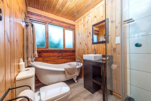 y baño con bañera, aseo y lavamanos. en Kariega Game Reserve Main Lodge, en Kenton on Sea