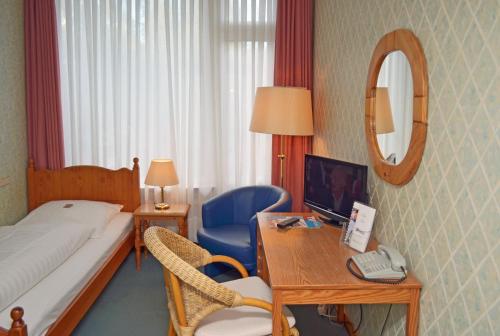 ein Hotelzimmer mit einem Bett und einem Schreibtisch mit einem Computer in der Unterkunft Motel Hamburg in Hamburg