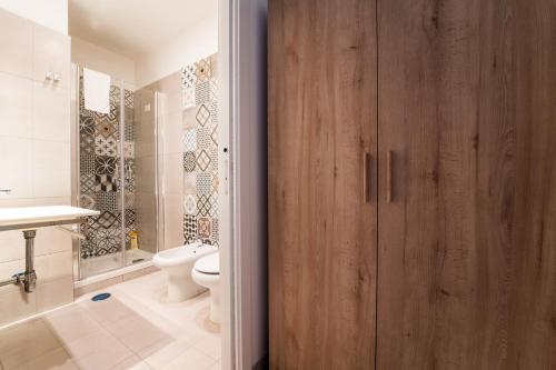 baño con puerta de madera y aseo en New Gallery, en Nápoles