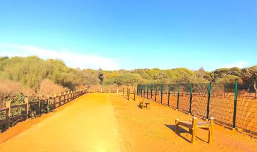 a walk way with a bench on a fence at Maison de Vacances Harhoura in El Harhoura