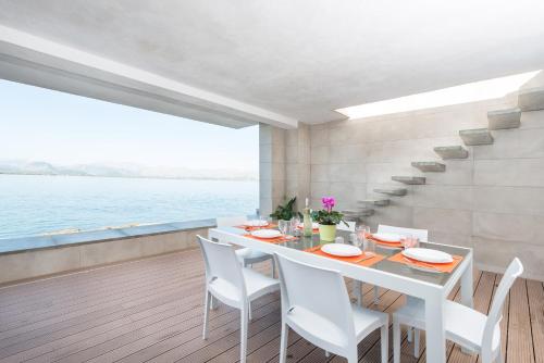a dining room with a white table and chairs at Aixa in Alcudia