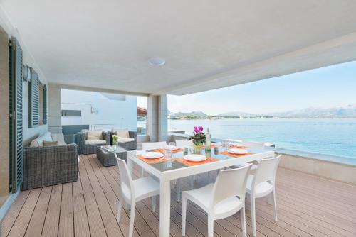 a dining room with a table and chairs and the ocean at Aixa in Alcudia