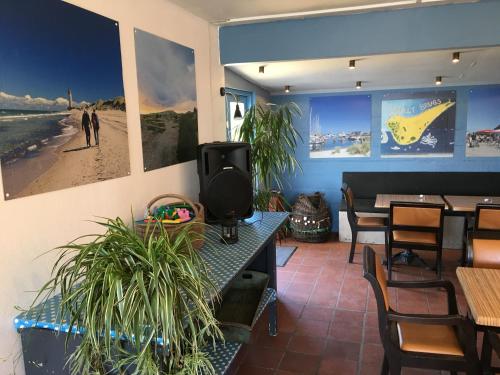 a restaurant with tables and chairs and pictures on the wall at Casablanca Hostel, hyggelig overnatning in Anholt