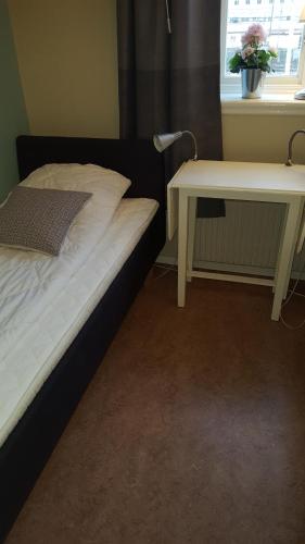 a bed with a desk next to a bed with a table at Centralstationens Vandrarhem in Norrköping