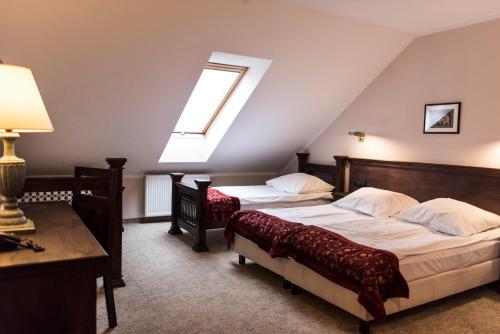 a attic bedroom with two beds and a window at Orient Palace in Bielany Wrocławskie