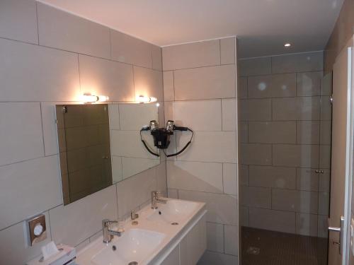 a bathroom with two sinks and a mirror at Petit Hôtel de Chaumont in Chaumont-de-Pury