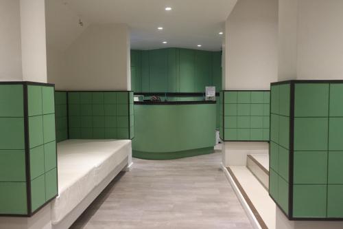 a room with two beds and green walls at L42 Hostel Suvarnabhumi Airport in Lat Krabang