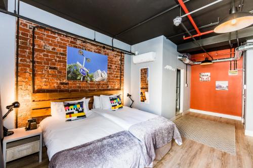 a bedroom with a bed and a brick wall at InnsCape on Castle Hotel in Cape Town