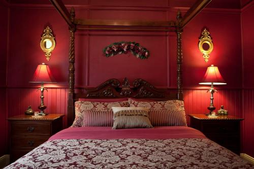 a bedroom with a bed with red walls and two lamps at Mountain Whispers Leura Rose in Leura