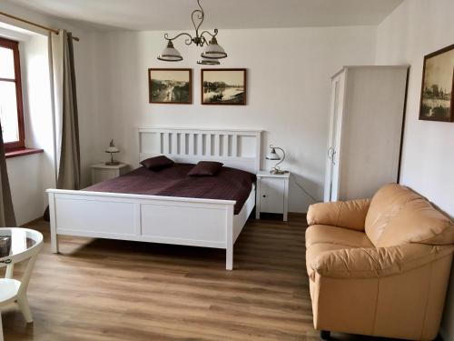 a bedroom with a bed and a couch at Penzion U Kapra in Roudnice nad Labem