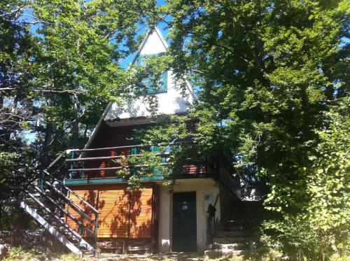 a tree house with stairs leading up to it at Planinska vikendica LUCIJA in Fužine