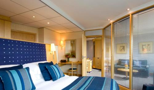 ein Hotelzimmer mit einem Bett mit blauen und weißen Kissen in der Unterkunft Bolton Stadium Hotel in Bolton
