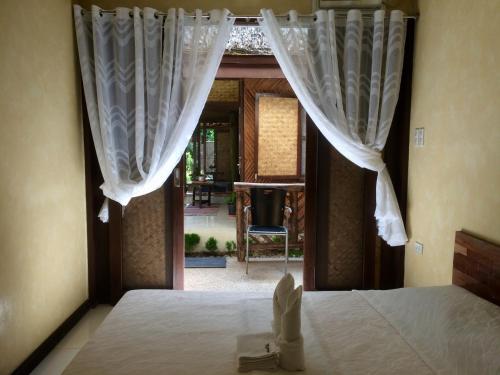 a bedroom with a bed with curtains on it at Le Cou de Tou Village Resort in San Vicente