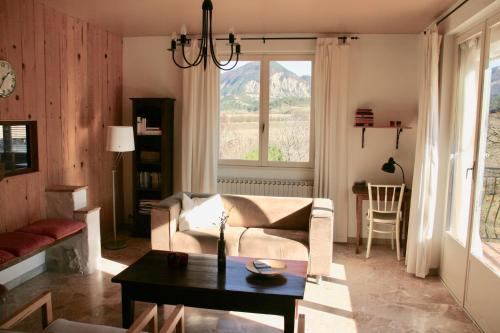 ein Wohnzimmer mit einem Sofa und einem Tisch in der Unterkunft Le Mas De Saint-Ferréol Etage in Menglon