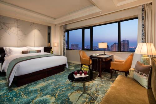 Cette chambre comprend un lit et une grande fenêtre. dans l'établissement The Pury Hotel, à Yiwu
