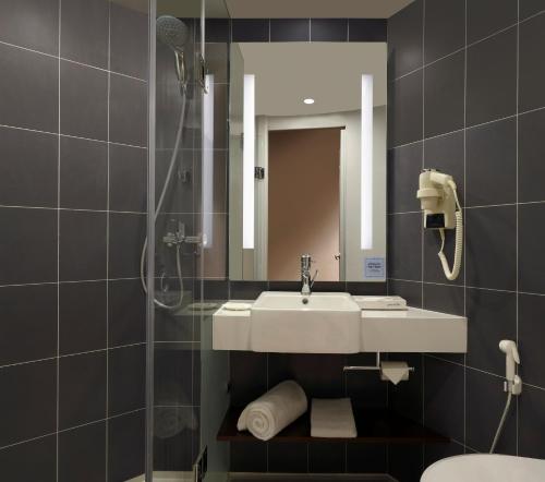 a bathroom with a sink and a shower at ibis Pune Hinjewadi - An Accor Brand in Pune