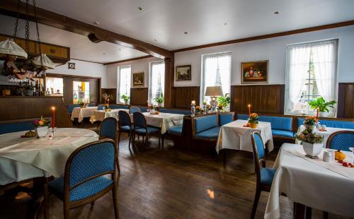 ein Restaurant mit Tischen und Stühlen in einem Zimmer in der Unterkunft Hotel Acht Linden in Egestorf