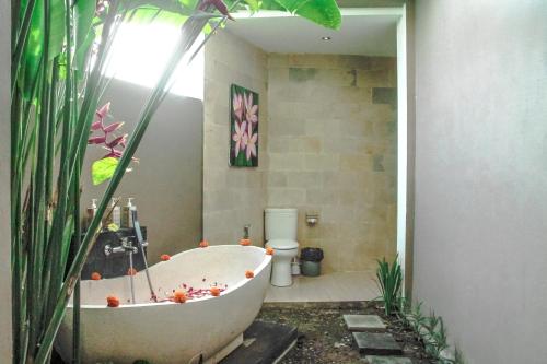 bagno con vasca e servizi igienici di Heavenly View Villa ad Ubud