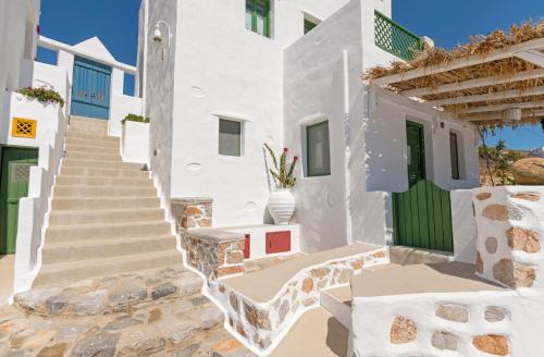 a staircase leading to a white building with a green door at Kalderimi Residencies in Astypalaia Town