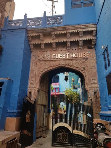 a blue building with a gate in front of a house at Yogis Guest House in Jodhpur