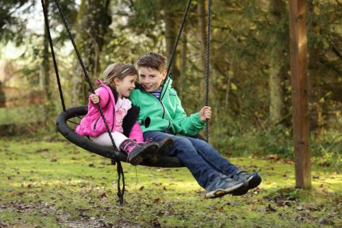 a young boy and girl sitting on a swing at Gästehaus Grünberger in Hutthurm