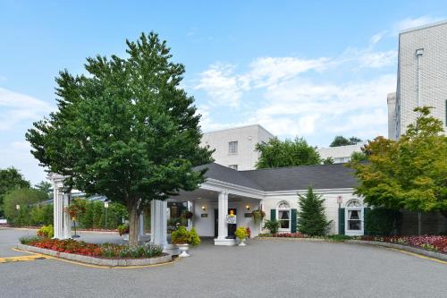 a white house with a tree in a driveway at The Madison Hotel in Morristown