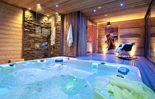 a jacuzzi tub in a room with a chair at Odalys Chalet Mont Soleil in Mâcot La Plagne