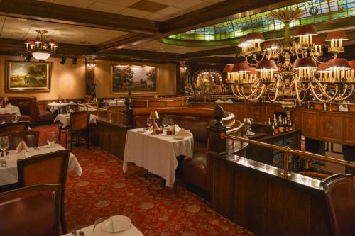 a restaurant with tables and chairs and chandeliers at The Madison Hotel in Morristown