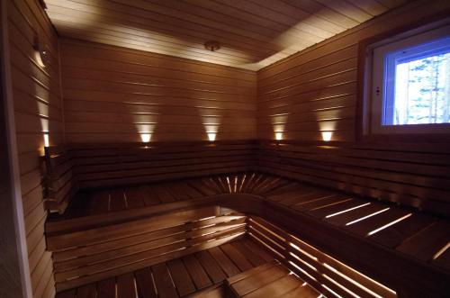 Una sauna de madera vacía con una ventana. en Villa Avanto, en Suomenniemi