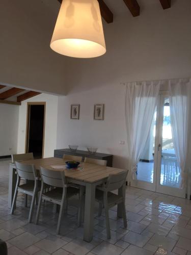 a dining room with a wooden table and chairs at NerOssidiana in Acquacalda