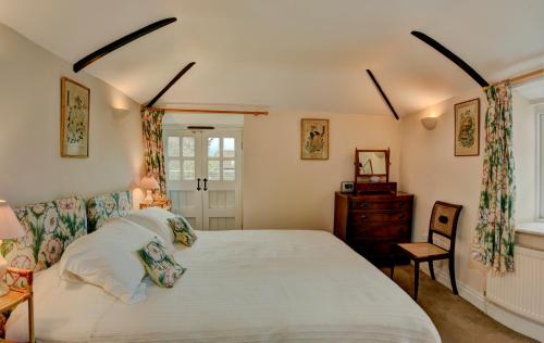 a bedroom with a large bed and a chair at The Barn @ Bishops Lydeard in Taunton